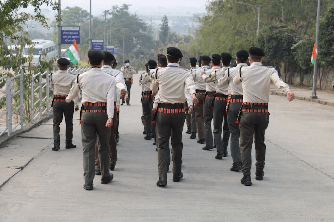 Security personnel marching in formation along institutional pathway